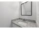 Bathroom vanity featuring a granite countertop, white cabinet and a framed mirror at 3 Cheltenham Dr, Clayton, NC 27520