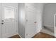 Bright entryway featuring a wooden floor, coat closet, and a door with built-in blinds at 3 Cheltenham Dr, Clayton, NC 27520
