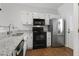 Well-lit kitchen features granite countertops, stainless steel refrigerator, and black appliances at 3 Cheltenham Dr, Clayton, NC 27520