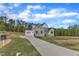 Stunning view of home, with three-car garage, manicured lawn, and a long winding driveway at 3803 Bennett Grove Dr, Wake Forest, NC 27587