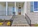 Covered porch with stone steps and wood door entrance featuring wrought iron railings at 3803 Bennett Grove Dr, Wake Forest, NC 27587