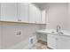 Functional laundry room with white cabinets, sink, and ample counter space at 3803 Bennett Grove Dr, Wake Forest, NC 27587