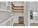 Well-organized pantry with white cabinets, quartz countertops, open wood shelving, and beverage fridge at 3803 Bennett Grove Dr, Wake Forest, NC 27587