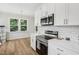 Modern kitchen with white cabinets, quartz countertops, and stainless steel appliances at 438 S Hillsborough St, Franklinton, NC 27525