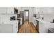Modern kitchen with white cabinets, quartz countertops, and stainless steel appliances at 438 S Hillsborough St, Franklinton, NC 27525