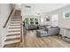 Open living room with staircase, sectional sofa, and wood-look floors at 438 S Hillsborough St, Franklinton, NC 27525