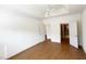 Spacious bedroom with hardwood floors, a ceiling fan, and doors leading to an ensuite bath at 4712 Fox Fern Ln, Raleigh, NC 27604