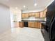Well-lit kitchen featuring wood cabinets and black appliances. Hardwood flooring can be seen in the adjacent room at 4712 Fox Fern Ln, Raleigh, NC 27604