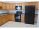 Kitchen with wood cabinets, granite countertops and black appliances at 4712 Fox Fern Ln, Raleigh, NC 27604