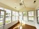 Bright sunroom with lots of windows and natural light, showcasing beautiful hardwood floors and a ceiling fan at 4712 Fox Fern Ln, Raleigh, NC 27604