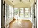 Bright sunroom with lots of windows and natural light, showcasing beautiful hardwood floors and a ceiling fan at 4712 Fox Fern Ln, Raleigh, NC 27604