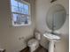 Powder room with pedestal sink and decorative round mirror at 6330 Granite Quarry Dr, Raleigh, NC 27610