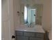 Bathroom vanity with grey cabinets, a large mirror, chrome fixtures and white countertop at 104 Halifax Rd, Louisburg, NC 27549