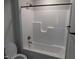 Full bathtub and shower with white tile and modern fixtures inside a full bathroom at 104 Halifax Rd, Louisburg, NC 27549