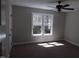 Bright bedroom featuring a window, ceiling fan and neutral color carpeting at 104 Halifax Rd, Louisburg, NC 27549