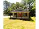 Charming single-story home featuring a covered porch and a striking red front door at 104 Halifax Rd, Louisburg, NC 27549