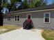 Rear exterior view of the home with gray siding, a red door, and a concrete patio at 104 Halifax Rd, Louisburg, NC 27549