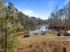 Lakeside backyard featuring lush trees, a trampoline, docks, and access to the water at 1119 Sagamore Dr, Louisburg, NC 27549