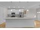 Bright kitchen features white cabinets, stainless steel appliances, and a large center island with stone countertop at 1119 Sagamore Dr, Louisburg, NC 27549