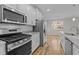 Modern kitchen featuring stainless steel appliances, granite countertops, and white cabinets at 1119 Sagamore Dr, Louisburg, NC 27549