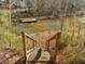 Wooden stairs leading down to a scenic lake view with a private dock at 1119 Sagamore Dr, Louisburg, NC 27549