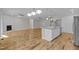 Open-concept living area with island, modern lighting, and seamless flow with wood floors at 1119 Sagamore Dr, Louisburg, NC 27549