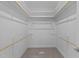 Spacious walk-in closet with carpet, white walls, and wood bars for hanging clothes at 1119 Sagamore Dr, Louisburg, NC 27549