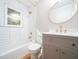 Stylish bathroom with modern fixtures, a bathtub with white tile surround and a window for light at 1302 E Jones St, Raleigh, NC 27610