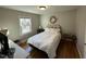 This bedroom features a hardwood floor, white linens, and natural light from the window at 1302 E Jones St, Raleigh, NC 27610