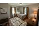 Bright bedroom with hardwood floors, patterned rug, two windows, and neutral wall color at 1302 E Jones St, Raleigh, NC 27610