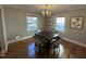 Bright dining room with a chandelier, hardwood floors, and natural light from two large windows at 1302 E Jones St, Raleigh, NC 27610