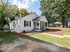 Charming, painted brick home with covered front porch and well-manicured lawn on a sunny day at 1302 E Jones St, Raleigh, NC 27610