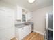Bright kitchen with stainless steel appliances, white cabinetry, granite counters, and hardwood floors at 1302 E Jones St, Raleigh, NC 27610