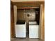 Convenient laundry area with washer and dryer, utility shelves, and wood paneled walls at 1302 E Jones St, Raleigh, NC 27610
