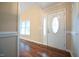 Elegant foyer with a decorative front door, gleaming hardwood floors, and natural light from the adjacent window at 1508 Woods Creek Dr, Garner, NC 27529