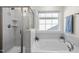 Clean bathroom with a shower, soaking tub, and large window at 168 Begonia St, Angier, NC 27501