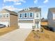Two-story home with a two-car garage, blue and white siding, dormer window, and well-manicured lawn at 168 Begonia St, Angier, NC 27501