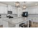 A spacious kitchen features granite counters, stainless appliances, pendant lighting, and stylish white cabinetry at 168 Begonia St, Angier, NC 27501