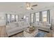 A bright living room with hardwood floors, neutral colored couches, decorative pillows, and large windows with curtains at 168 Begonia St, Angier, NC 27501