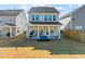 Home's rear exterior featuring a covered patio, a grill, and a spacious yard, perfect for outdoor gatherings at 168 Begonia St, Angier, NC 27501