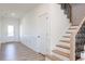 Bright entryway with wood floors, wainscoting, and staircase at 2012 Clydner Dr, Apex, NC 27523