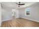 Bright bedroom with wood-look floors, ceiling fan, and access to another room at 2207 Edwin Ave, Durham, NC 27705