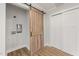 Bright laundry area with sliding barn door and modern wood-look flooring at 2207 Edwin Ave, Durham, NC 27705