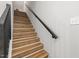 Wooden staircase with a black handrail and white walls with new paint at 2207 Edwin Ave, Durham, NC 27705