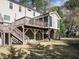A two-story deck and backyard is highlighted by mature trees, and a home with light brown siding at 505 Annandale Dr, Cary, NC 27511