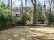 Large grassy backyard with black metal fence, mature trees, and glimpses of a home at 505 Annandale Dr, Cary, NC 27511