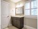 This bathroom features a dark vanity with granite countertops and a large mirror, with natural light streaming through plantation shutters at 505 Annandale Dr, Cary, NC 27511