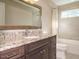 Well-lit bathroom with granite countertops, dark wood cabinetry, and a shower-tub combination at 505 Annandale Dr, Cary, NC 27511