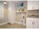 Laundry room with sink, white cabinets, and storage shelves at 505 Annandale Dr, Cary, NC 27511