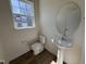 Cozy powder room featuring a pedestal sink, round mirror, and wood-look flooring at 6332 Granite Quarry Dr, Raleigh, NC 27610